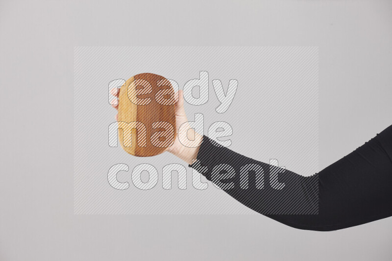 امرأة ترتدي عباءة سوداء تحمل أدوات خشبية مختلفة في أوضاع متعددة