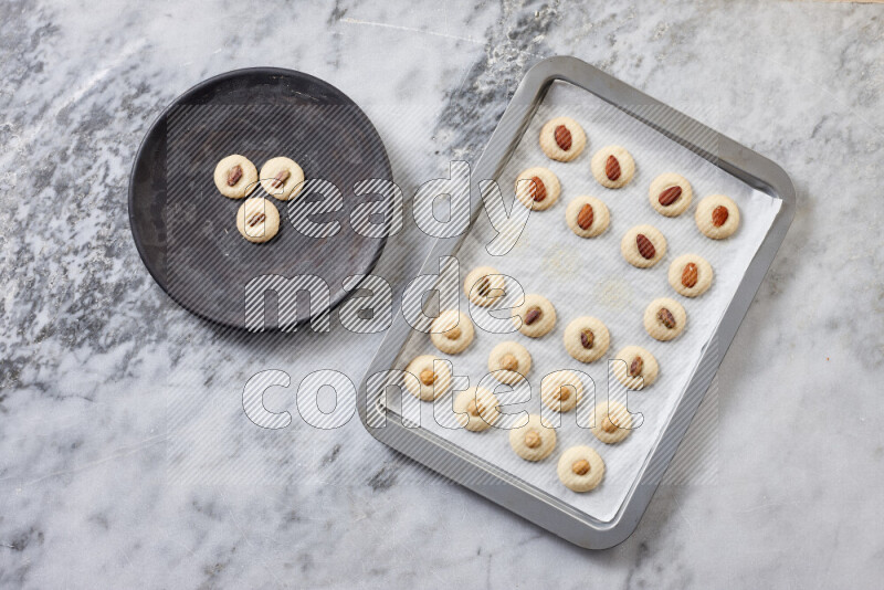 غريبة خطوة بخطوة بالمكونات الدقيق والسكر البودرة والسمن والمكسرات على خلفية رخام رمادي