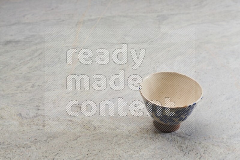 A multicolored pottery bowl on grey marble background