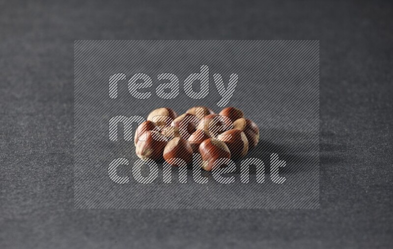 A bunch of hazelnuts on a black background in different angles