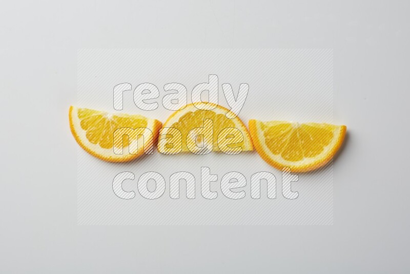 Three halves of an orange slices on white background