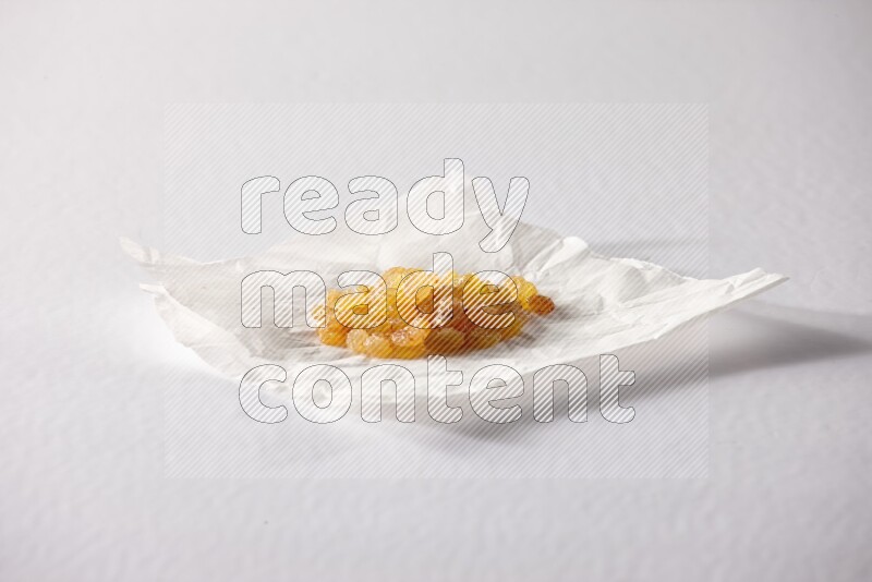 Raisins on a crumpled piece of paper on a white background in different angles