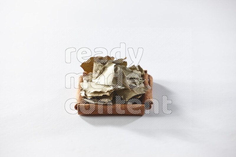 A single square of cinnamon sticks full of laurel bay on white flooring