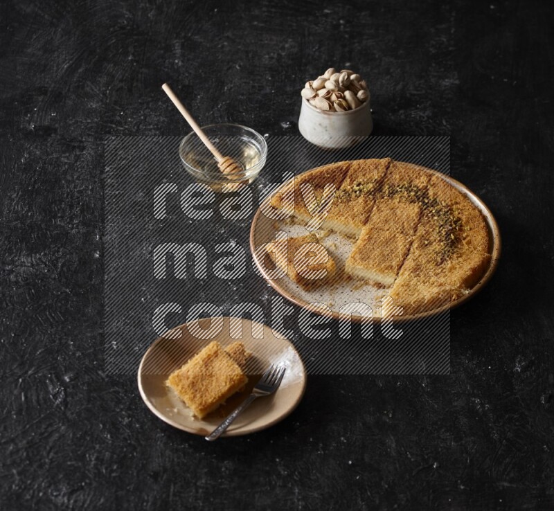 Konafa with nuts and honey in a dark setup