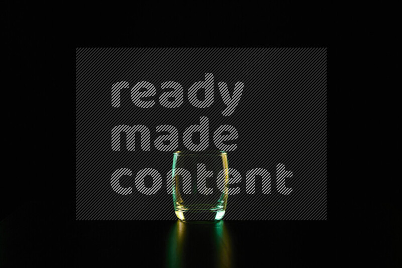 أواني زجاجية مع حواف مضيئة باللونين الأخضر والأصفر على خلفية سوداء