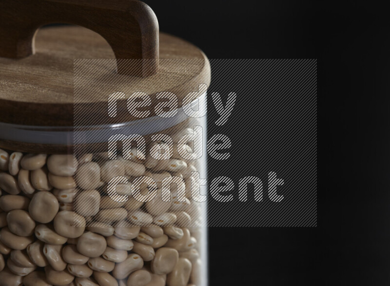 Lupin Beans in a glass jar on black background