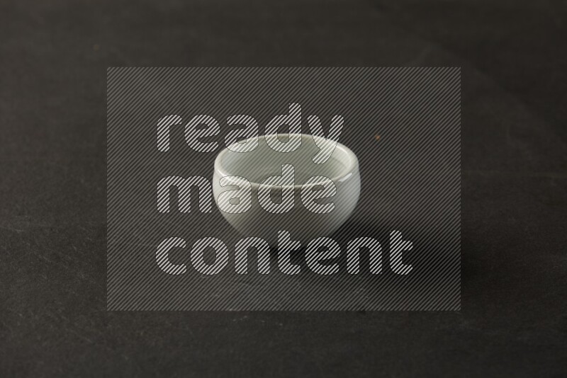 white ceramic round sauce bowl on grey textured countertop