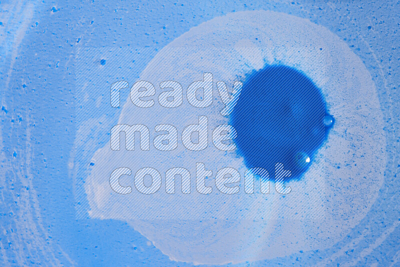 تلتقط الصورة تناثرا للطلاء الأزرق علي خلفية زرقاء