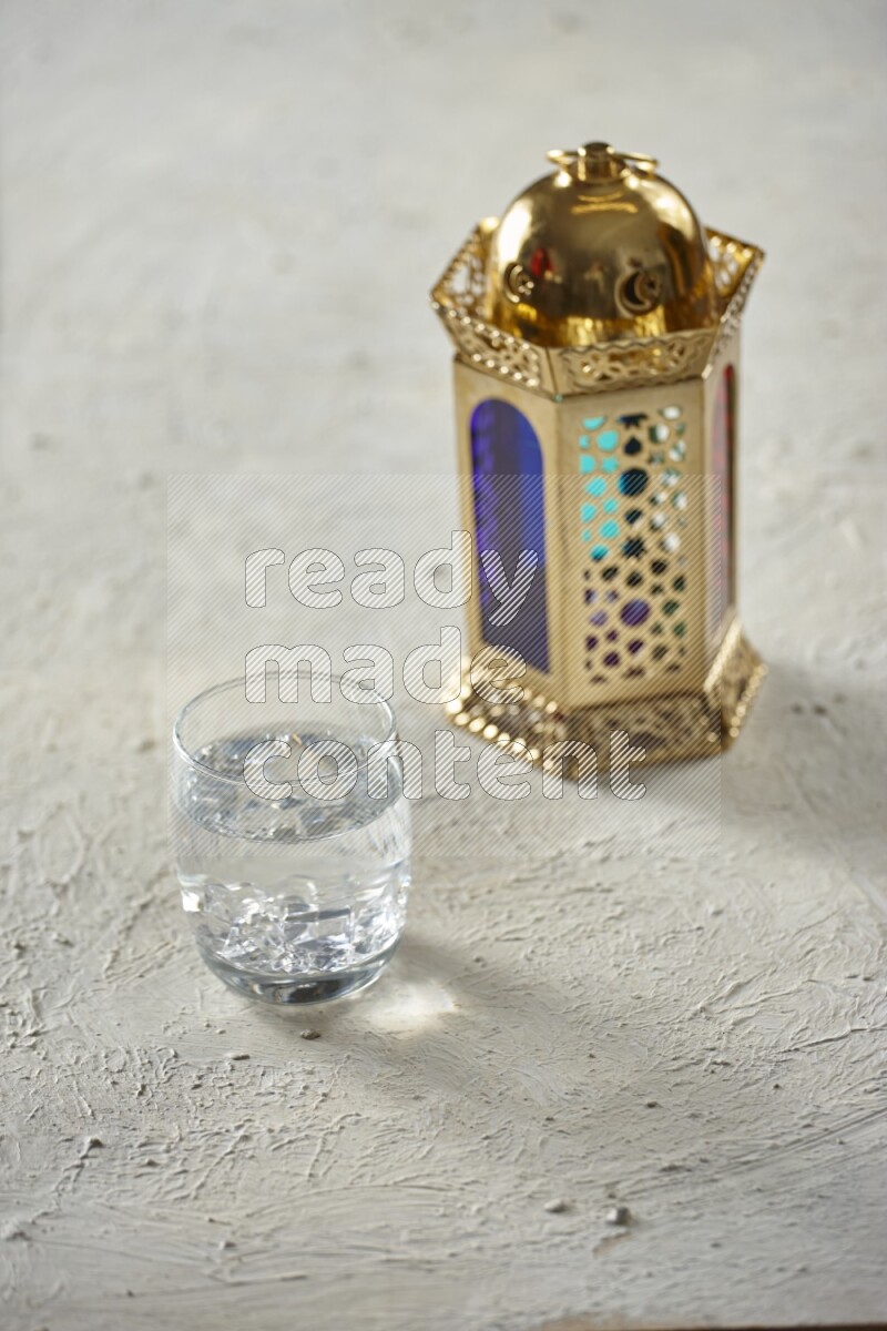 A golden lantern with different drinks, dates, nuts, prayer beads and quran on textured white background