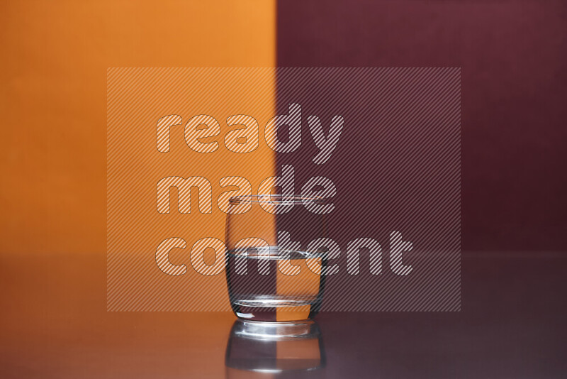 The image features a clear glassware filled with water, set against orange and dark red background