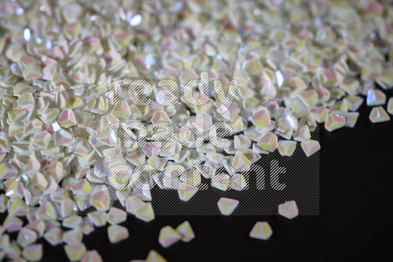 Colorful plastic shards for decoration scattered on a black background