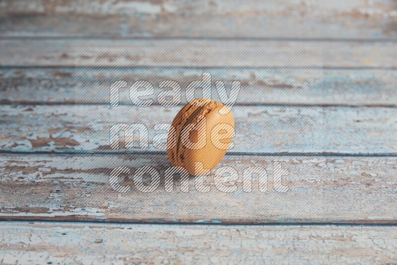 45º Shot of Brown Maple Taffy macaron on light blue wooden background