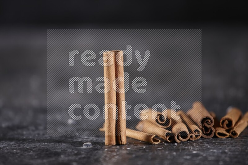 Cinnamon sticks on a textured black background