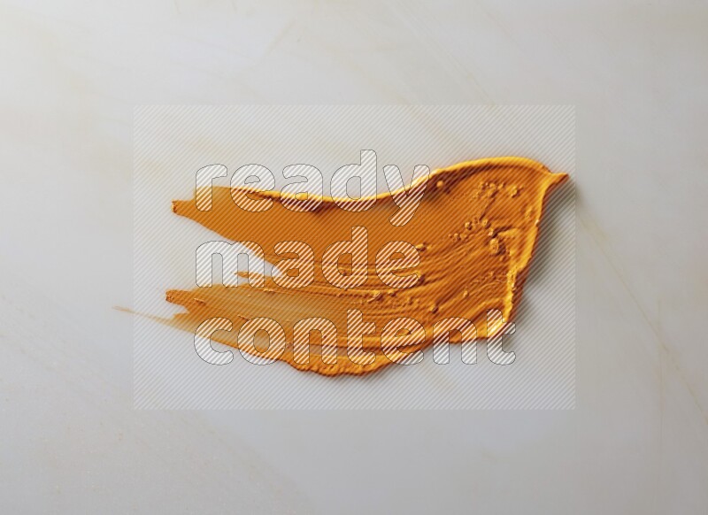 An orange single curved painting knife stroke on white background