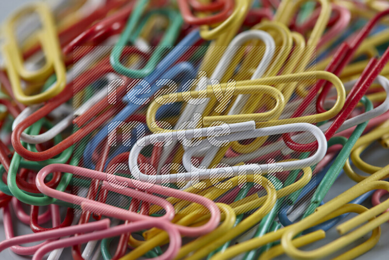 Multicolored paper clips isolated on a grey background