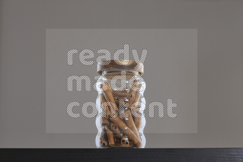 أعواد من القرفه في وعاء زجاجي على خلفية سوداء