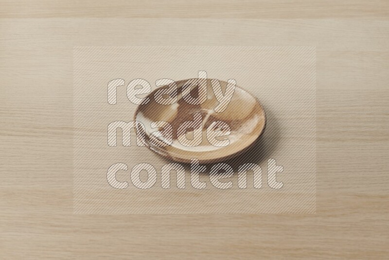 A multicolored pottery plate on light wooden background