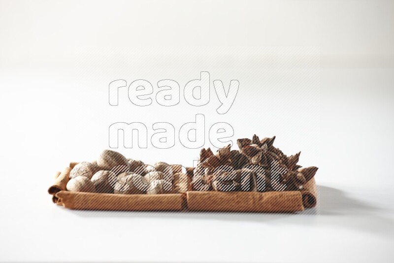 2 squares of cinnamon sticks full of star anise and nutmeg on white flooring