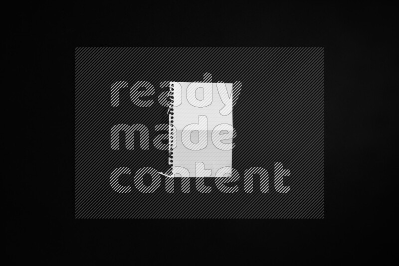 Folded notebook sheet on black background