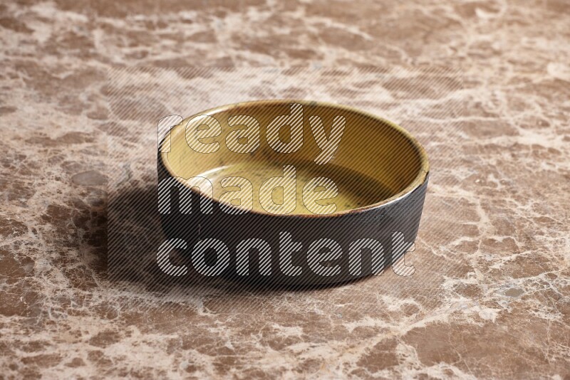 A multicolored pottery oven plate on beige marble background
