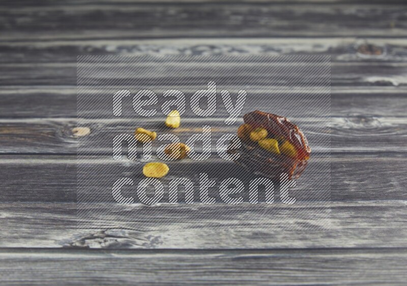 pistachio stuffed madjoul date on a wooden grey background
