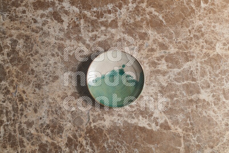 A decorative pottery plate on beige marble background