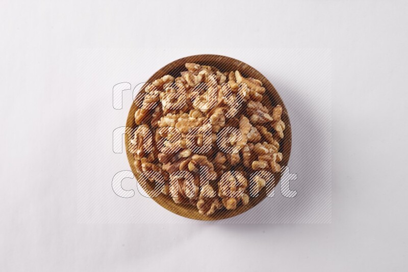 Walnuts in a wooden bowl on white background