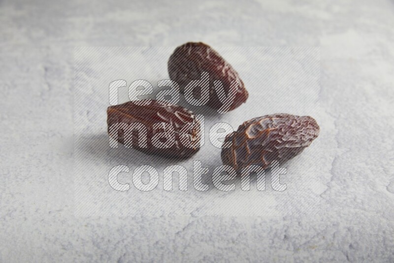 three madjoul dates on a light grey background