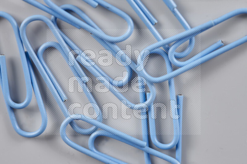 Blue paper clips isolated on a grey background