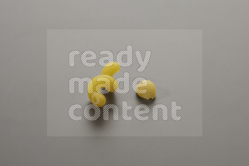 Twist pasta with other types of pasta on grey background