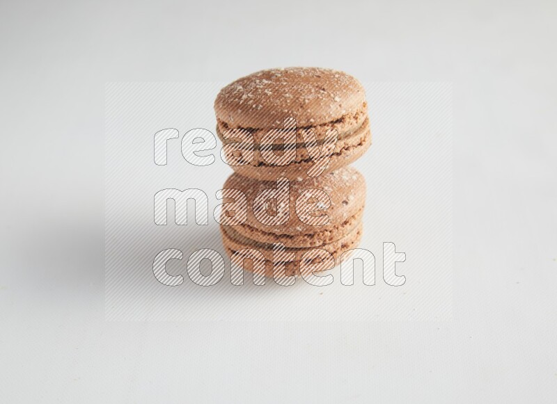 45º Shot of two Brown Hazelnuts macarons on white background