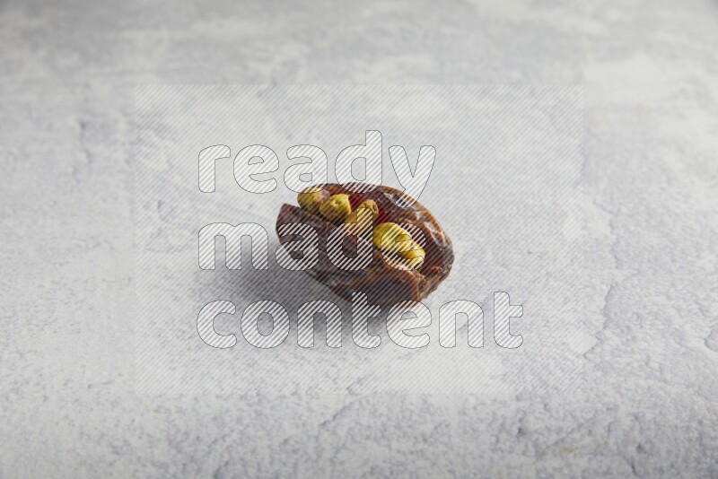 pistachio stuffed madjoul date on a light grey background