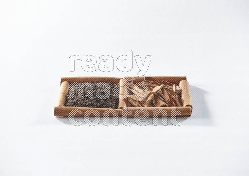 2 squares of cinnamon sticks full of black tea and cinnamon on white flooring