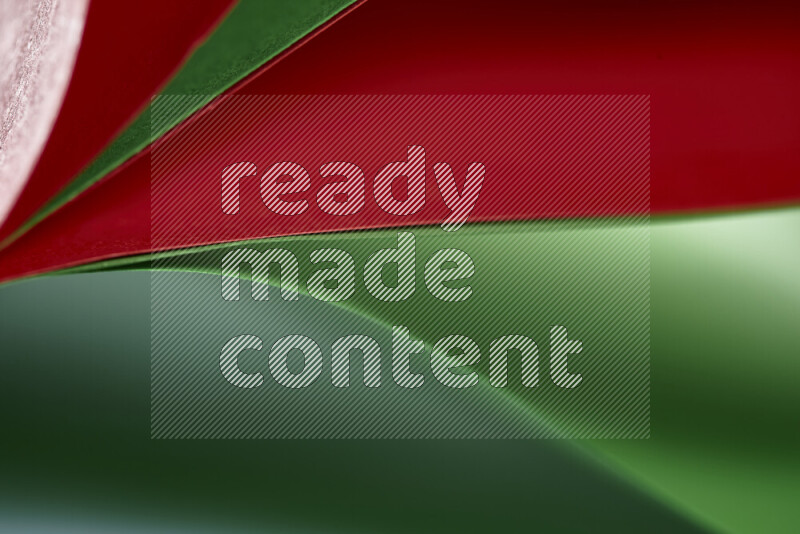 An abstract art showing red and green paper sheets arranged in an overlapping curves