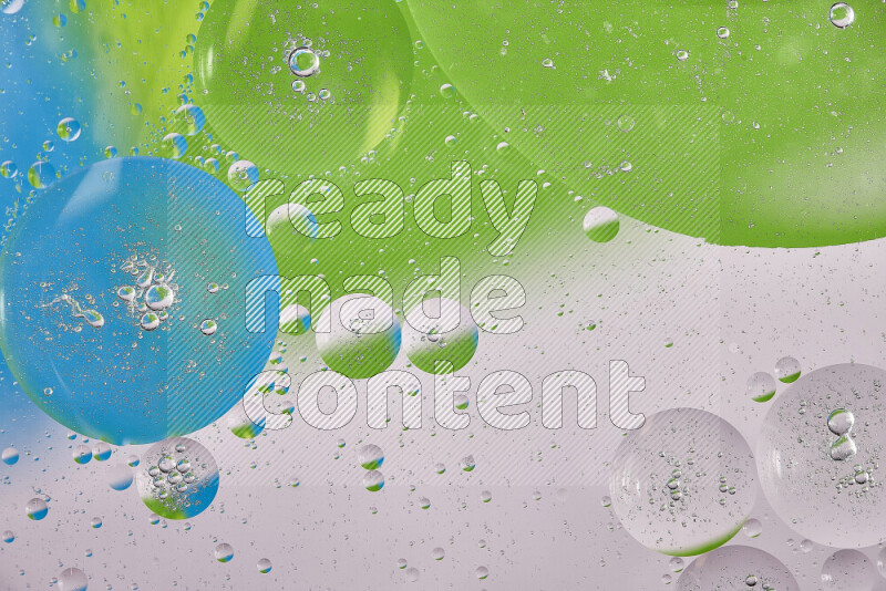 Close-ups of abstract oil bubbles on water surface in shades of white, green and blue