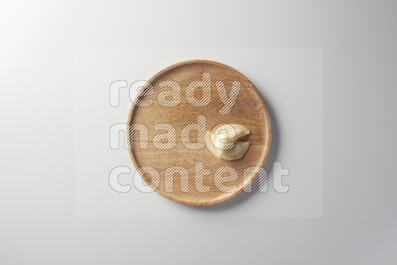 Two Sambosas on a wooden round plate on a white background