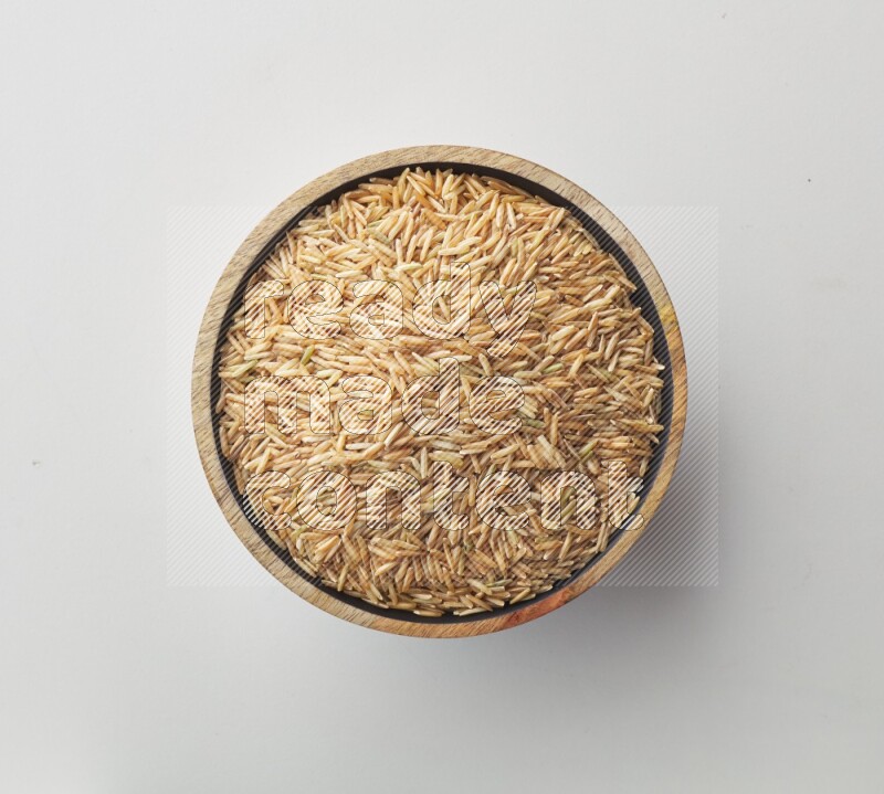 Top-view shot of long grain brown rice in a container on white background