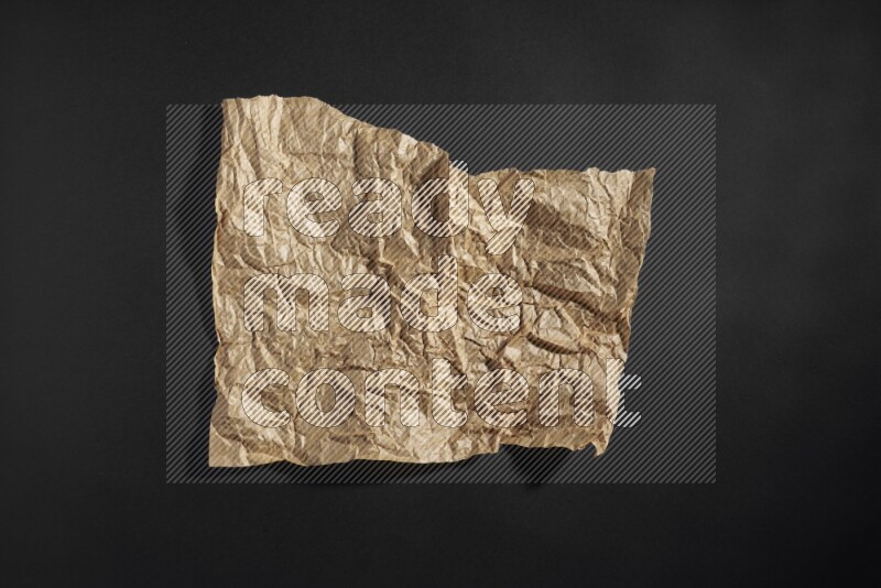 Crumpled craft paper on black background