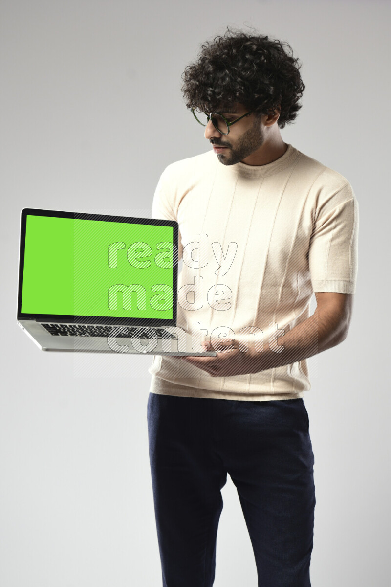 A man wearing casual standing and showing a laptop screen on white background