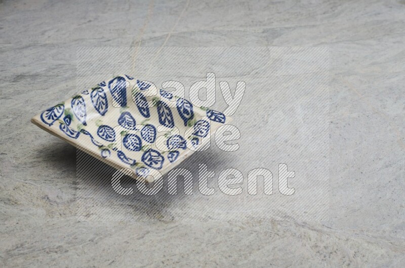 A decorative pottery plate on grey marble background