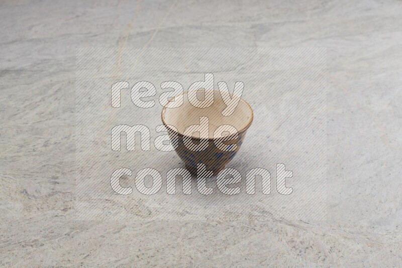 A multicolored pottery bowl on grey marble background