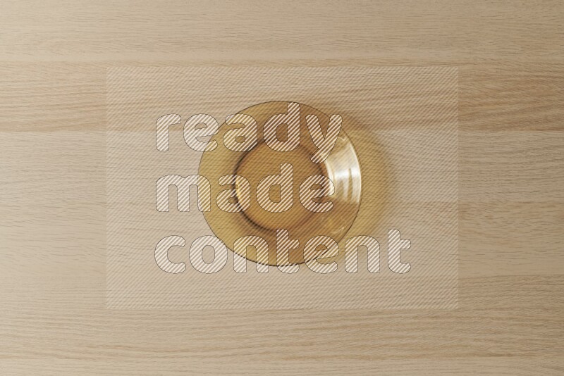 A circular glass plate on light wooden background