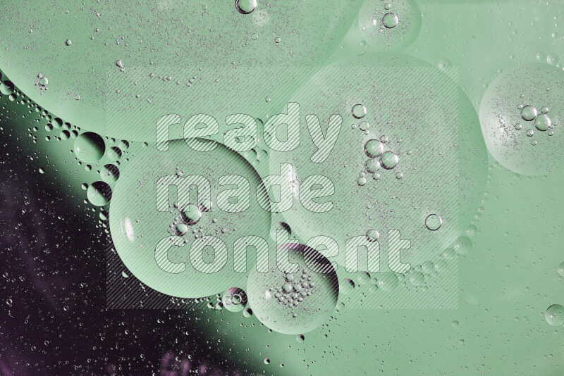 لقطات مقربة لفقاعات من الزيت على سطح الماء باللون الأسود والأخضر