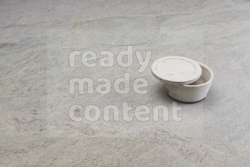A white pottery bowl on grey marble background
