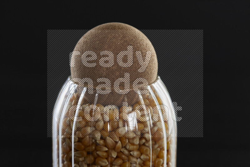 Pop corn in a glass jar on black background