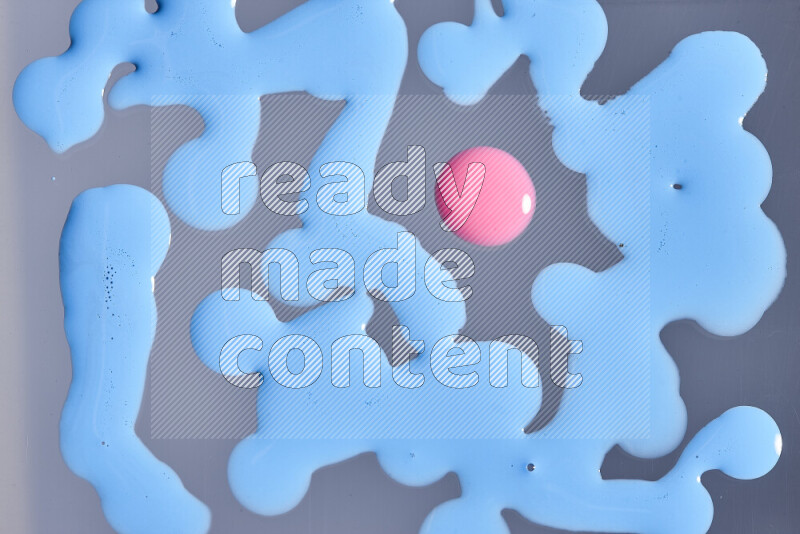 لقطات مقربة لقطرات من اللون الوردي والأزرق على الخلفية