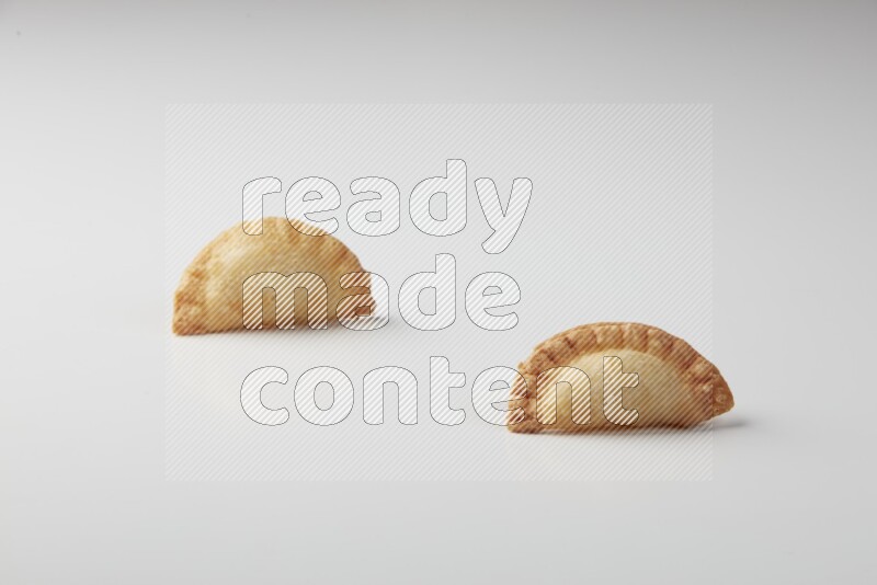 Two fried sambosas on a white background