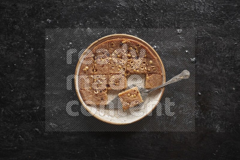 Basbousa in different plates in a dark setup