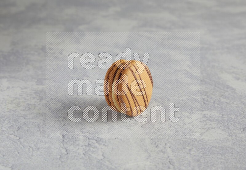 45º Shot of light brown  Almond Cream macaron on white  marble background