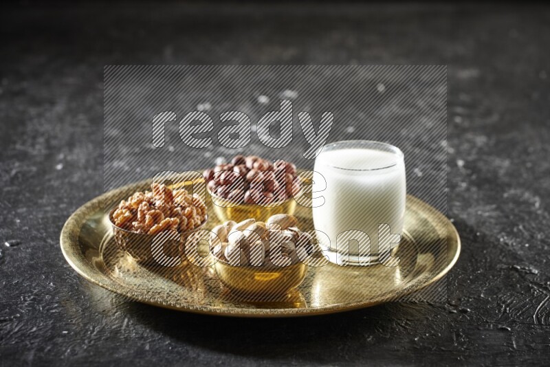 Nuts in metal bowls with sobya on a tray in dark setup